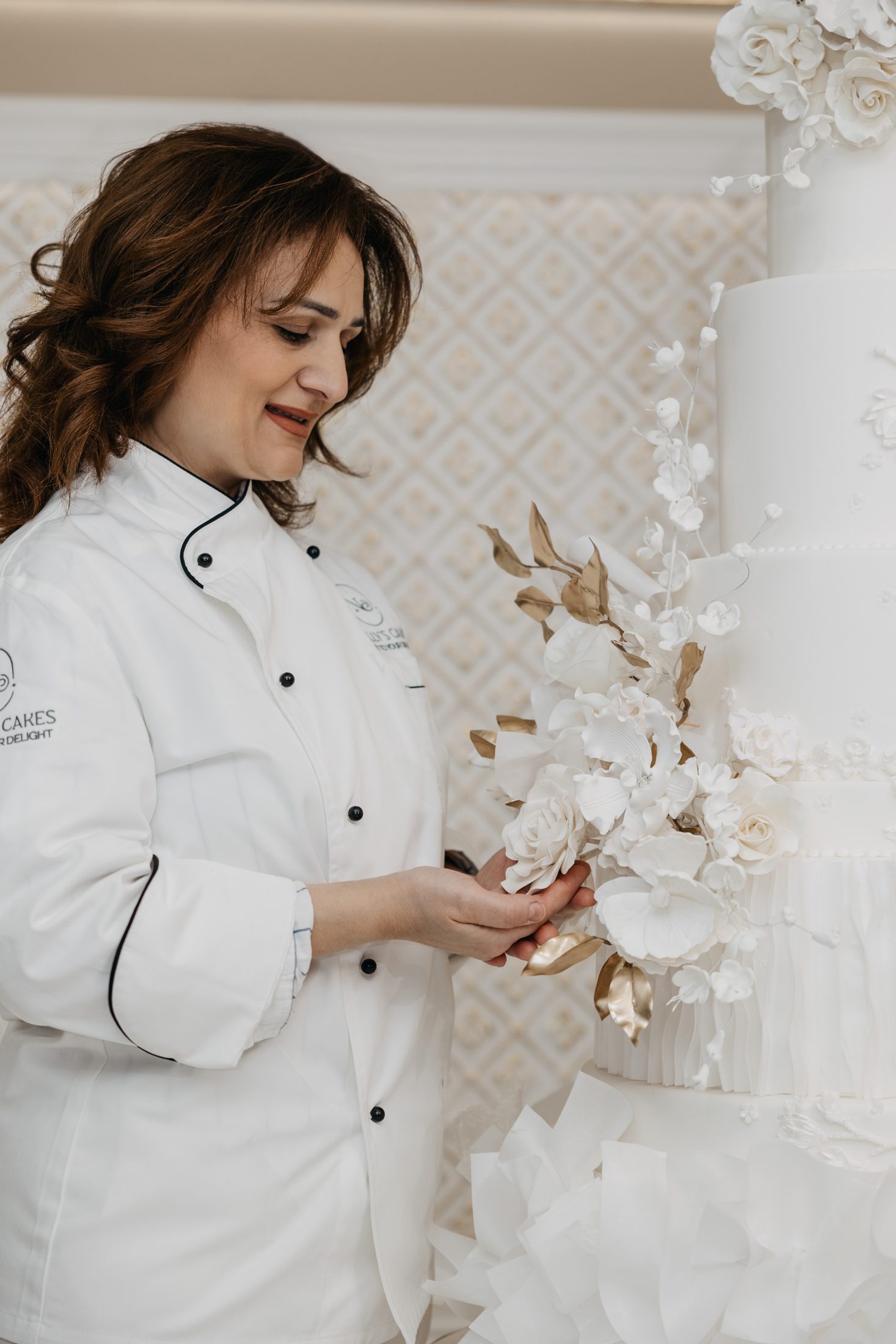 Nelly placing a hand-made sugar flower on a wedding cake