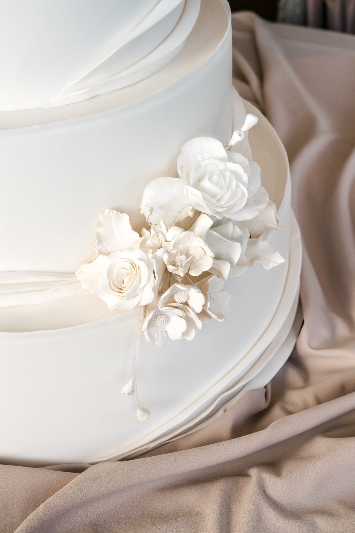 A soft satin fold and sugar roses on white fondant